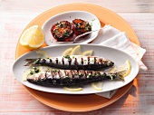 Grilled herring with baked tomatoes in serving dish