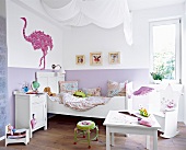 Blick in ein Kinderzimmer mit Bett, Kommode, Schaukelstuhl und Tisch