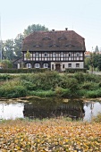 Exterior of timber house beside pond, Saxony, Germany