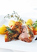 Close-up of duck breast with potatoes and rosemary on plate