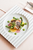 Sea bass with asparagus, lettuce and green puree on serving dish