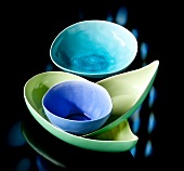 Colourful ceramic bowls on black background
