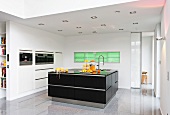 View of kitchen with glossy white walls, cabinets and black kitchen island