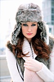 Portrait of red haired woman with grey eyes wearing fur hat with ear flaps