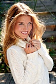 Portrait of attractive blonde woman wearing white turtleneck sweater, smiling