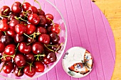 Close-up of cherries in bowl and painted stone on table