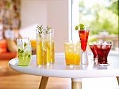 Glasses of lemonade and other drinks on table
