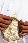 Close-up of person holding kummah in Salalah, Dhofar, Oman