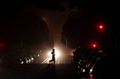 Person jogging on illuminated road in San Francisco, California, USA