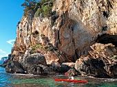 Person kayaking at Grotto in Gulf of Orosei, Sardinia, Italy
