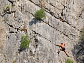 Man climbing rock mountain at Caletta Fuili, Cala Gonone, Sardinia, Italy