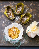 Steamed coconut cake in banana leaves with apple and ginger crumble in bowl