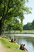 People sitting at Aachener Weiher in Belgian Quarter, Cologne, Germany