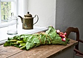 Rhubarb wrapped with leaves on wooden table