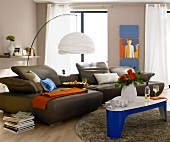 Living room with floor lamp, table and brown leather sofa with docking station