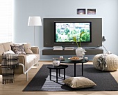 Living room with sofa, cushions, floor lamp and TV wall