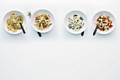 Four different types of pasta in bowls