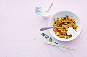 Lentils with apricots in bowl on pink background