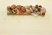 Four types of cinnamon buns on wooden board