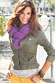 Portrait of attractive woman wearing green jacket and purple scarf, smiling