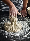 Close-up of hand kneading sticky dough
