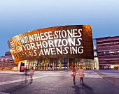 Illuminated exterior of Millennium centre in Cardiff at night, Wales, UK, blurred motion