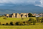 View of Beaumaris castle at Island of Anglesey with mountain ranges in background, Wales