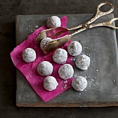 Cream truffles on gray board with tongs