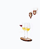 Two white wine glass on wood against white background