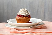 A chestnut cupcake topped with cranberries and chestnut cream frosting