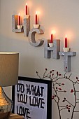 Red candles on decorative letters on a wall