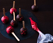 Close-up of red and brown cake pops on plate