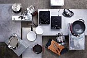 Pots, knives, induction hotplates and various kitchen utensils, overhead view