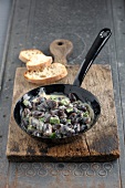 Bean seeds in frying pan on wooden chopping board
