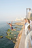 Young people jumping from railing at Corniche El-Manara, Beirut, Lebanon