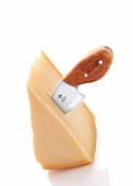 Parmesanmesser steckt in einem Stück Parmesan, Käse, Grana