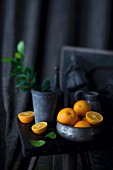 An arrangement of oranges in a bowl and on a stool