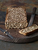Polynuclear bread on wooden board with knife