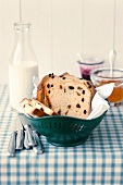 Sliced raisin bread in bowl with milk bottle