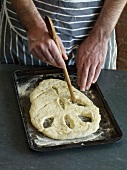 Close-up of making shapes on dough for preparation of fougasse, step 3