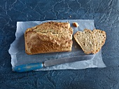 Sliced Swedish whole meal bread with knife on baking paper