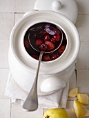 Rum and red garden fruits in pot with spoon