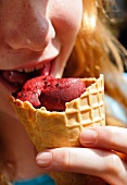Close-up of girl eating blueberry sorbet ice-cream
