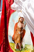 Jesus on red flag during Sant'Efisio procession, Pula, Sardinia, Italy