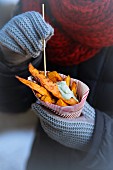 Sweet potato chips with a herb sauce in a paper cone