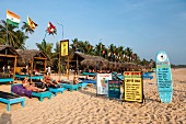 Tourists relaxing at Hikkaduwa beach with signboard around, Sri Lanka