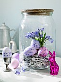 Purple Easter eggs in a preserving jar with an Easter bunny in front of it