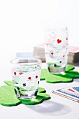 Shot glasses with playing card decor on clover shaped coasters