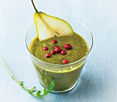 Green drink with pear and berries in glass