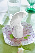 Floral pattern dish with porcelain parakeet on table